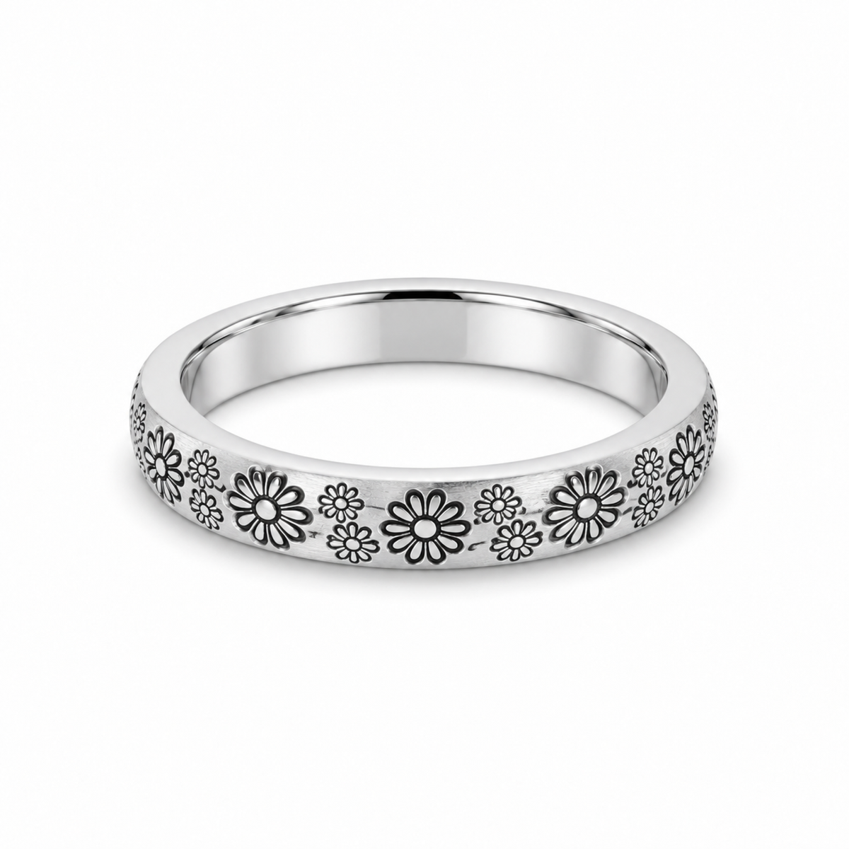 A platinum wedding ring featuring a continuous pattern of engraved daisy flowers.