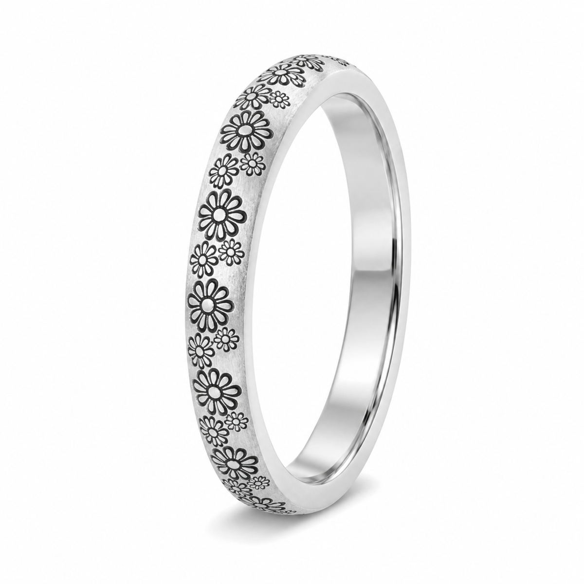 A platinum wedding ring featuring an engraved pattern of small black and white daisy flowers along the outer edge.