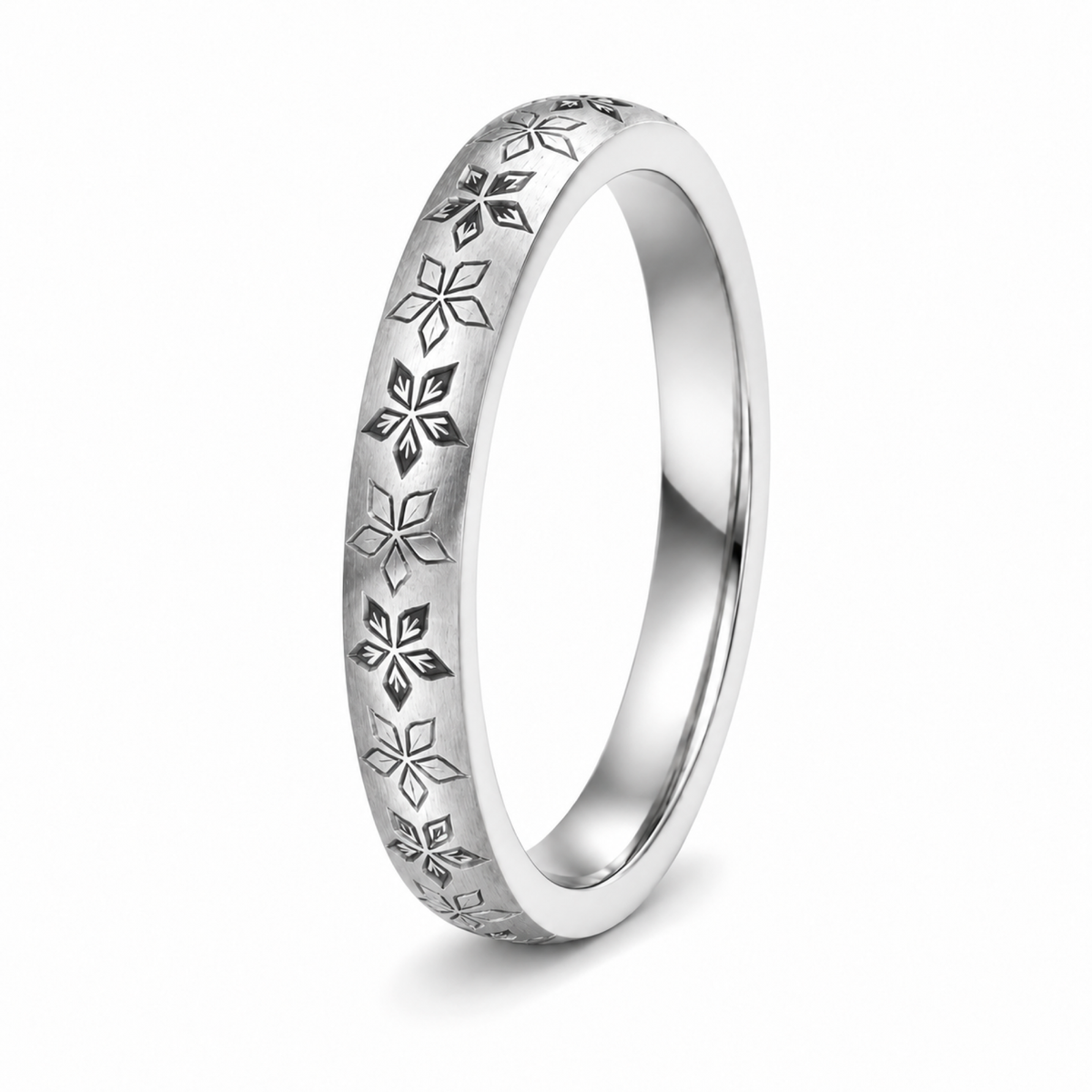 A platinum wedding ring with engraved floral snowflake patterns.