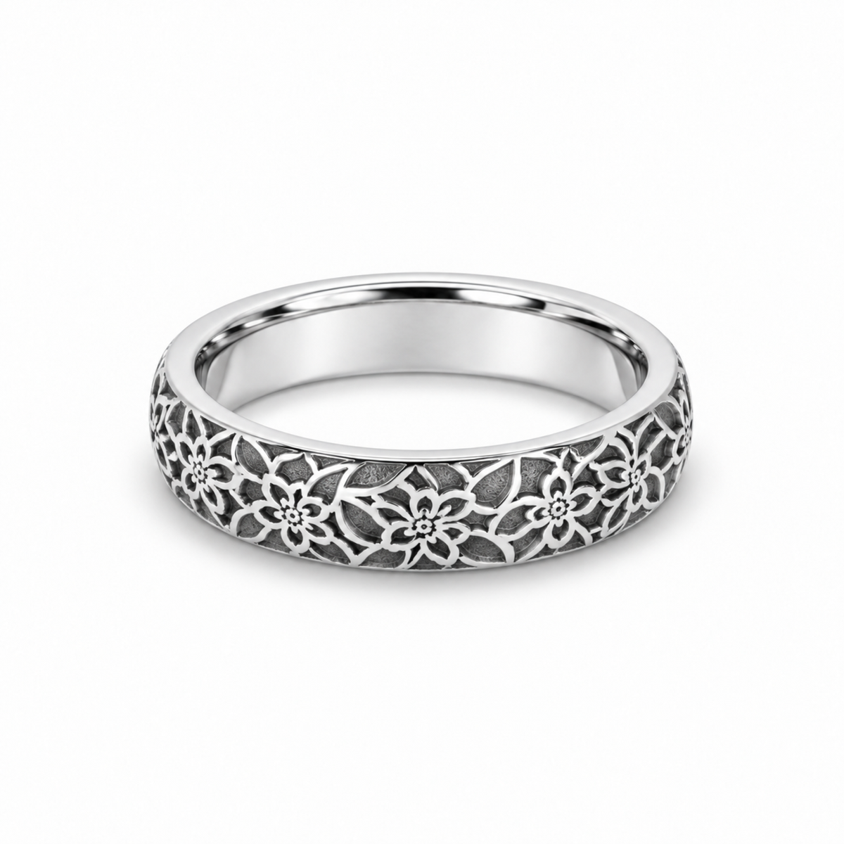 A platinum wedding ring featuring an intricate floral filigree pattern on the outer surface.