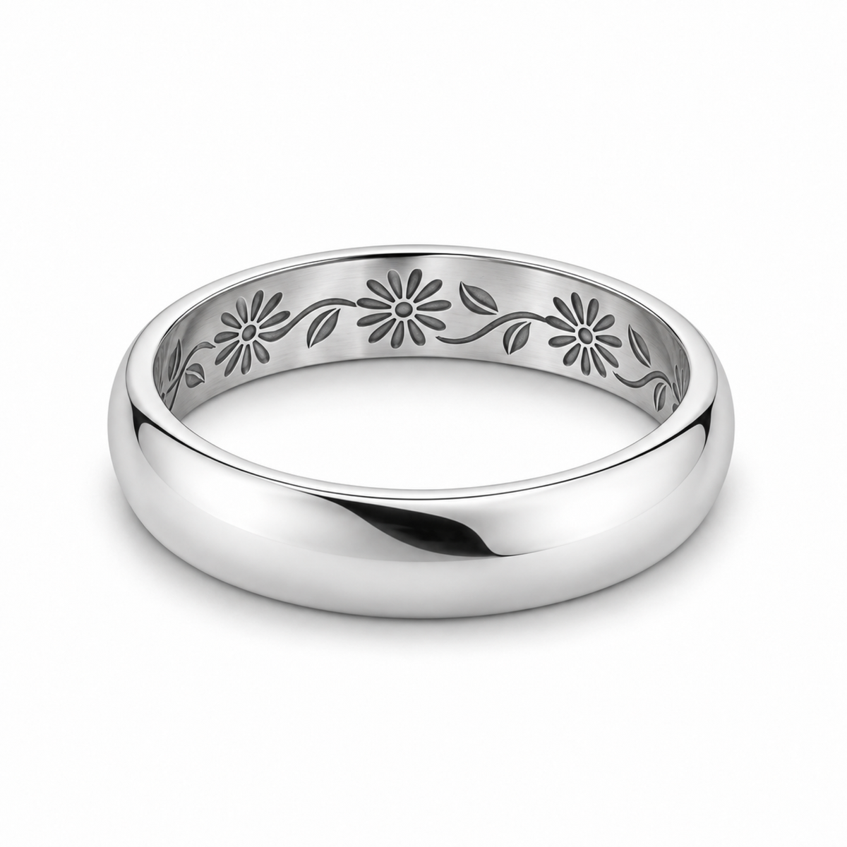 A polished platinum wedding ring with an engraved floral pattern inside.