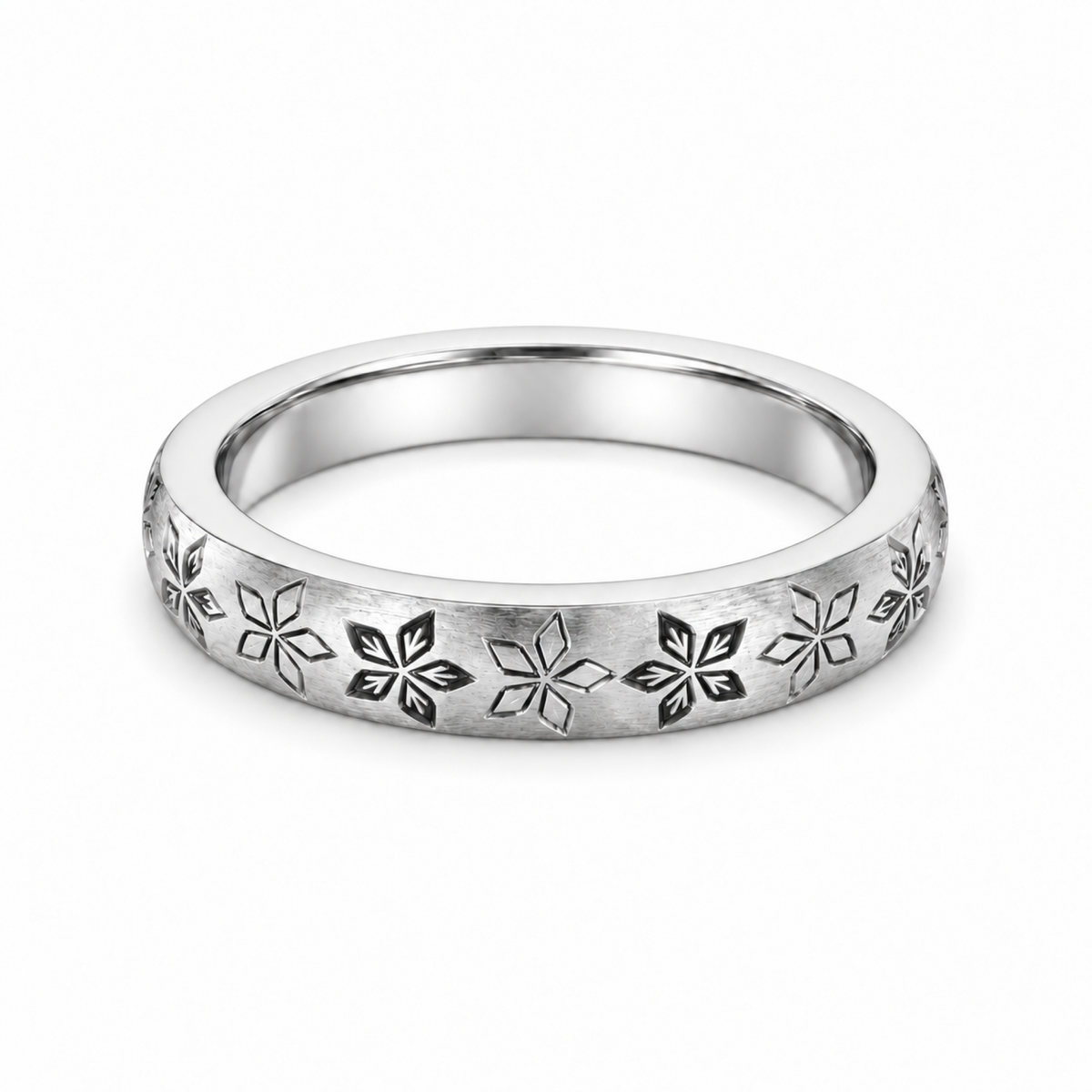A platinum wedding ring featuring a repeating engraved floral or snowflake-like pattern.