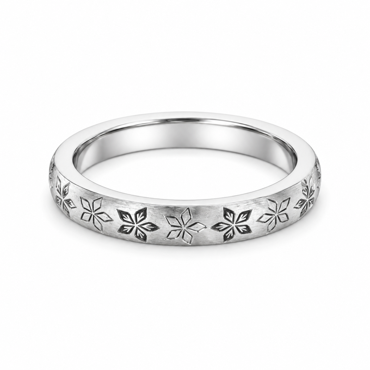 A platinum wedding ring featuring a repeating engraved floral or snowflake-like pattern.