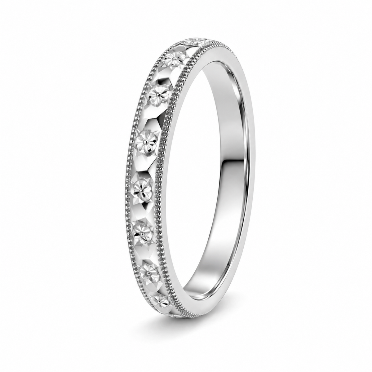 A platinum wedding ring with a floral engraved pattern.