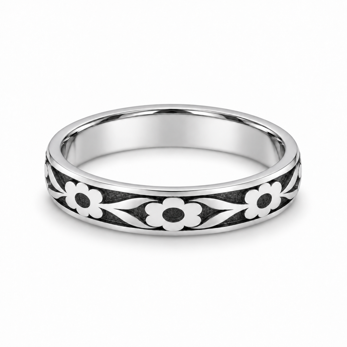 A platinum wedding ring featuring a black and white floral inlay pattern.