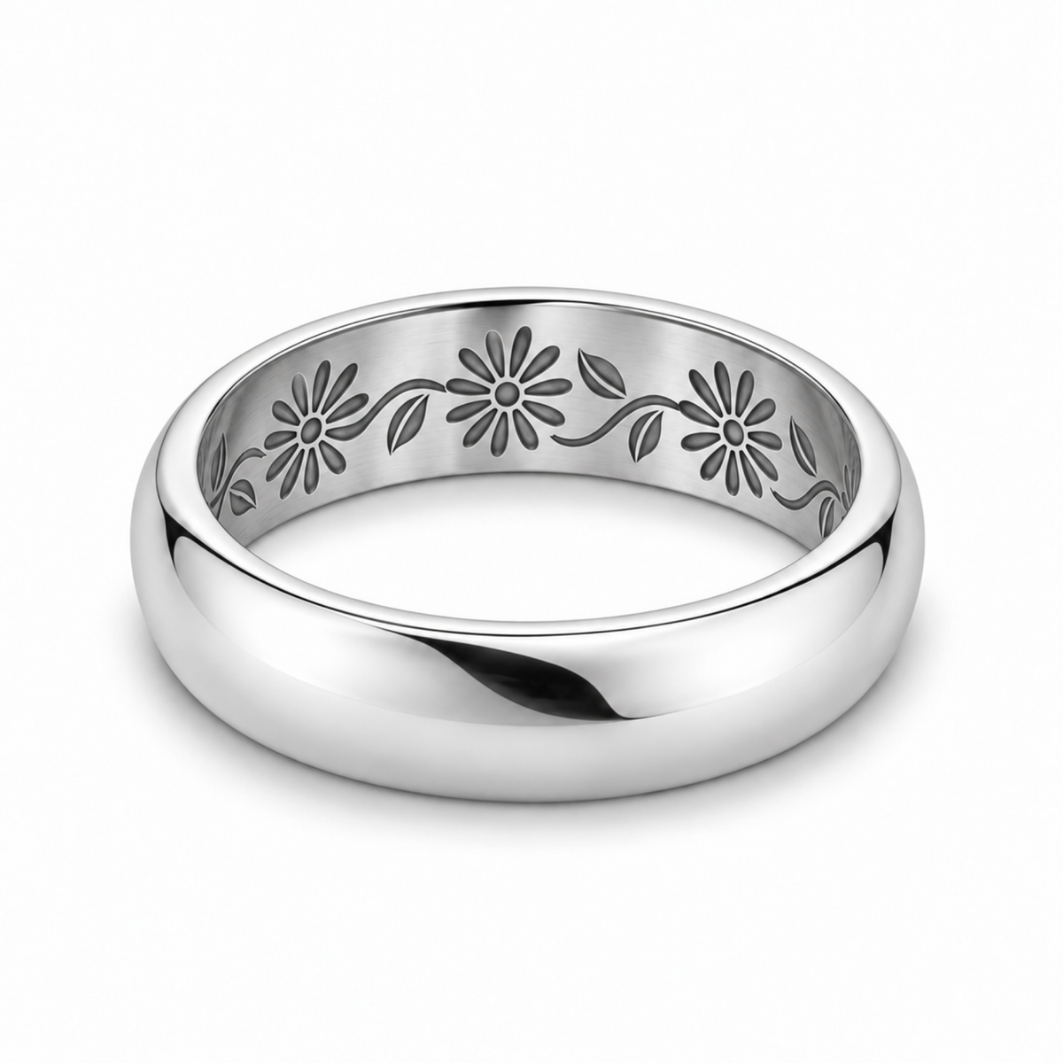 A platinum wedding ring with an engraved floral pattern inside.