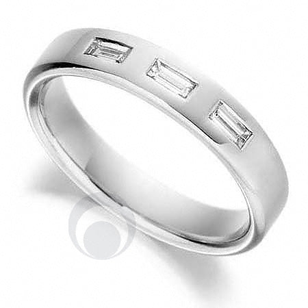 A diamond platinum wedding ring with a polished finish, featuring a baguette cut diamond centerpiece.
