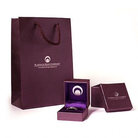 A photo of a platinum ring company gift bag and box.